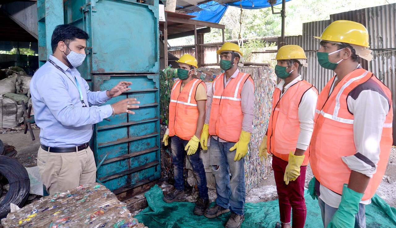 gemcorp's workers in a uniform standing and listening to their manager in the company