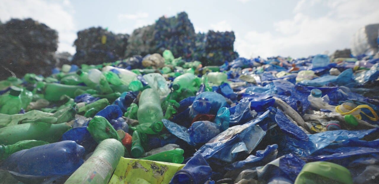 a picture of a mountain of plastic bottle in a landfill