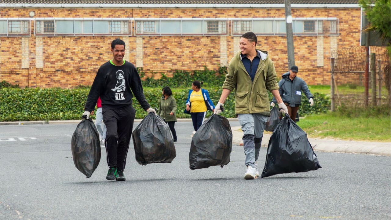 recovery entities waste pickers two men happily carrying two plasti bags full of plastic waste to recover